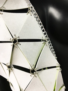 Détail des panneaux holographiques géométriques et des anneaux métalliques du top rave