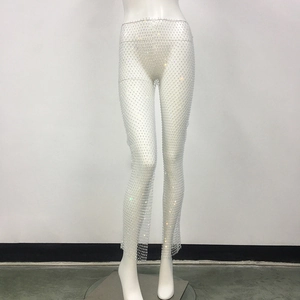 Macro detail of white high-elastic fishnet trousers with sparkling rhinestones overlay