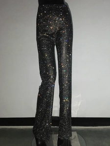 Dettaglio dei pantaloni a rete neri con strass colorati scintillanti per feste serali