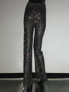 Dettaglio dei pantaloni neri a vita alta a gamba larga con strass multicolori scintillanti