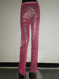 Dettaglio dei pantaloni in rete rosa con strass scintillanti e tessuto trasparente