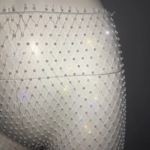 Detailed macro shot of white mesh trousers with sparkling rhinestones for party wear