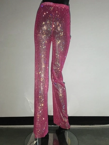 Dettaglio dei pantaloni a rete rosa con strass scintillanti e finitura ad alta brillantezza