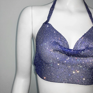 Macro detail of a blue rhinestone halter top with glittering crystals on metallic mesh