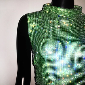 Detail shot of green rhinestone mesh top showing sparkling crystals and high collar texture