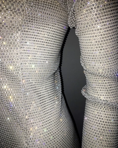 Detailed macro view of white mesh dress featuring dense crystal rhinestone embellishments