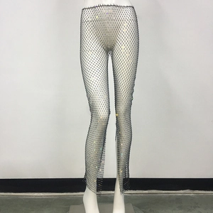 Close-up of black mesh pants featuring colorful rhinestones and side-slit hem detail