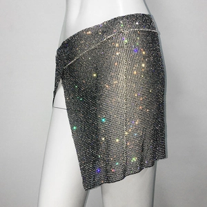 Détail des strass colorés brillants sur une jupe en maille noire asymétrique