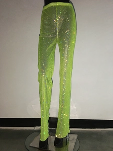 Dettaglio dei pantaloni a rete verde neon con strass colorati scintillanti