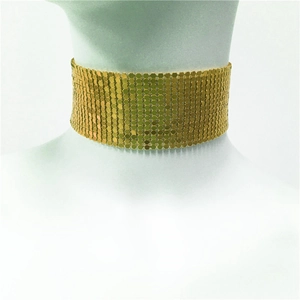 Detailed macro shot of the shiny gold metal sequin mesh texture on the choker necklace