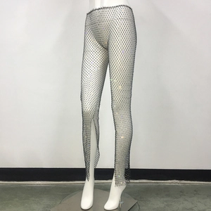 Detailed view of high-waist black mesh fishnet pants with colorful rhinestones and side slit