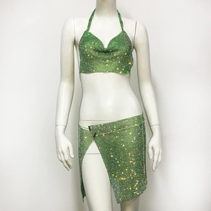 Detail of green rhinestone mini skirt set featuring sparkling halter top and side slit
