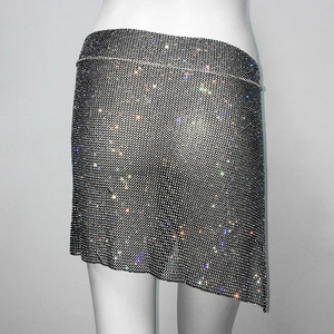 Détail de strass scintillants sur mini-jupe asymétrique en mesh noir pour les fêtes