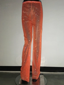 Vista dettagliata dei pantaloni a rete arancioni con strass luccicanti per feste