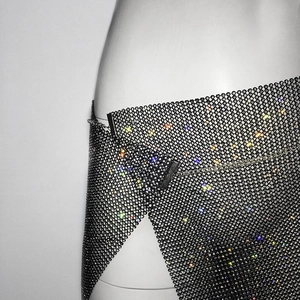 Vue détaillée de la jupe en maille noire avec strass colorés et chaîne de réglage