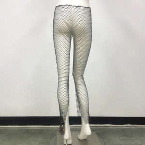 Macro detail of high-stretch fishnet leggings with sparkling colorful rhinestones decoration