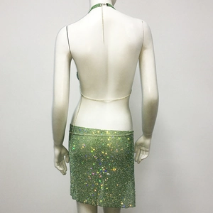 Detail of green rhinestone two-piece set featuring halter neck chain and mesh back design