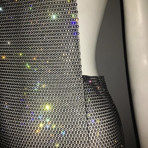 Close-up of sparkling rhinestones on a sexy black mesh party dress with shimmer detail