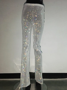 Dettaglio ravvicinato di strass lucidi su pantaloni a gamba larga in rete argentata