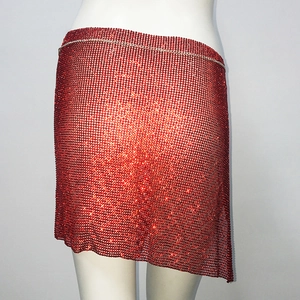 Détail d'une mini-jupe en résille à strass rouges avec ourlet asymétrique et chaîne de taille