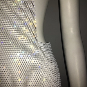 Close-up of sparkling rhinestones and mesh texture on sexy mini dress detail