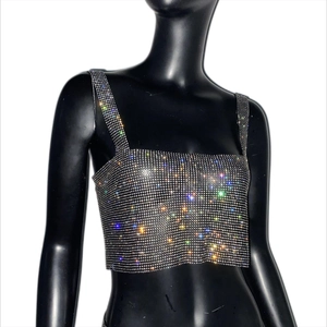 Dettaglio ravvicinato del crop top in rete di strass argento scintillante per feste e club