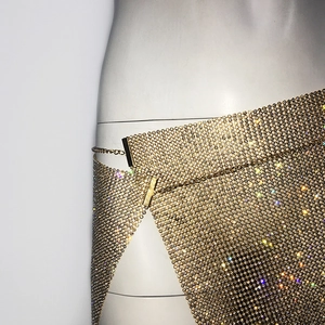 Vue détaillée d'une jupe luxueuse en maille strass dorée avec boucle latérale réglable