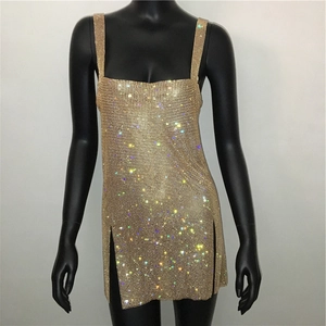 Dettaglio del vestito con paillettes dorate, strass scintillanti e spacco laterale alto