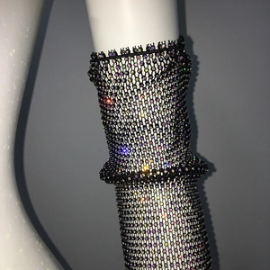 Détail macro de manchettes résille noires avec strass irisés scintillants et dentelle