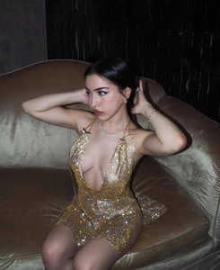 Nahaufnahme von goldenem Pailletten-Minikleid mit Metallic-Finish auf Samt-Hintergrund