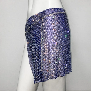 Détail d'une jupe en maille de strass bleu foncé avec chaînes argentées scintillantes