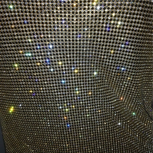 Vista macro di tessuto a maglia metallica dorata con strass di cristallo scintillanti