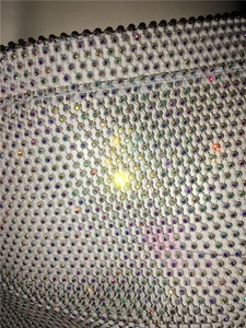 Close-up of sparkling rainbow AB rhinestones on luxury fishnet mesh fabric detail