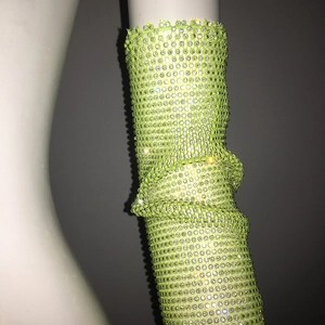 Détail de manches en maille vert néon avec strass brillants pour tenue de soirée