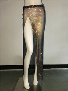 Detail view of shimmering rhinestones on black mesh fabric with high side slit