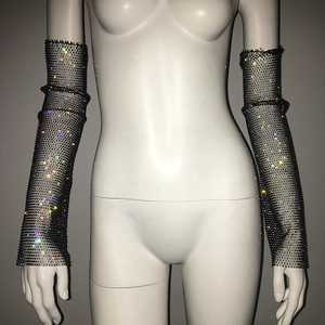 Close-up of black fishnet long arm sleeves with shimmering multicolored rhinestones