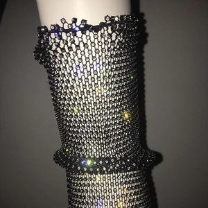 Close-up of black mesh fabric with sparkling white rhinestones on a decorative sleeve