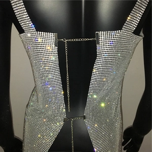 Dettaglio del vestito a rete in strass argento con catene metalliche regolabili