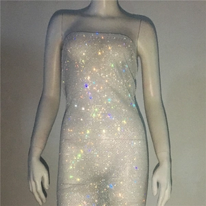 Detail view of sparkly multicolored rhinestones on translucent mesh bodycon dress