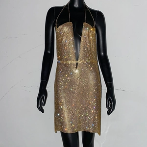 Détail de la mini-robe en maille dorée avec strass scintillants et encolure licou chic