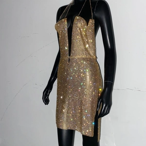 Détail de robe dos nu dorée avec décolleté en V profond et texture en strass étincelants