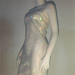 Macro shot of sparkling rhinestones on champagne strapless bodycon tube dress fabric