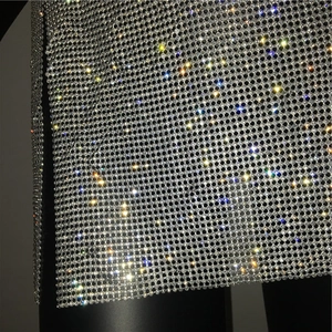 Dettaglio della maglia in strass argento scintillante e spacco laterale sull'abito
