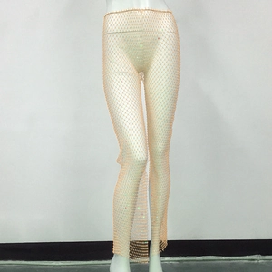Macro detail of elastic fishnet mesh pants featuring colorful rhinestones and side slits