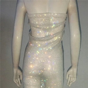 Close-up of sparkling colorful rhinestones on a beige mesh tube dress with sequins