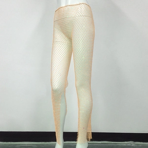 Detailed view of elastic mesh trousers with sparkling colorful rhinestones and hollow mesh