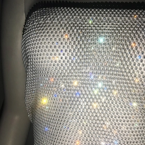 Detail of a sparkling rhinestone fishnet dress showing intricate crystal mesh texture