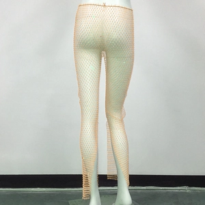 Detail of champagne mesh trousers with sparkling rhinestones and hollow net texture