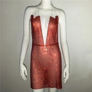 Détail d'une robe licou rouge à paillettes avec décolleté en V profond et chaînes