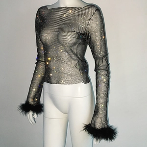 Detail of black mesh top featuring colorful rhinestones and elegant feather trimmed cuffs